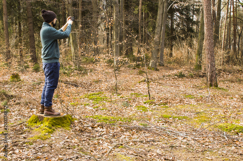 man taking photo with smartphone in the forest