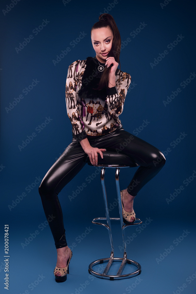 Super bright high elastic Women's patent leather leggings, lead dancer  costumes. Sexy brunette female in black leather jacket and in latex pants.  Gorgeous beautiful sexy girl in leather clothes. Stock Photo