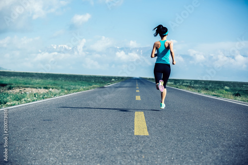 Young fitness healthy lifestyle woman runner running on wide road
