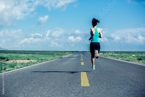 Young fitness healthy lifestyle woman runner running on wide road
