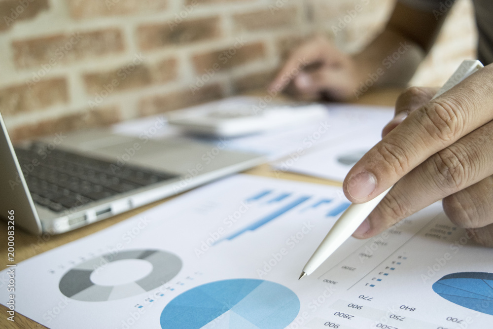 The capitalist is examining the company's finances to prepare his company. The capitalist is examining the company's finances to prepare his company.