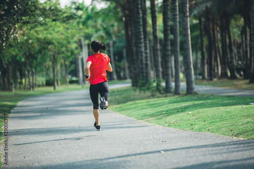 sporty fitness woman running at tropical park
