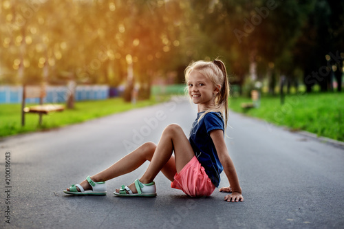 little girl in dress walking in summer park
