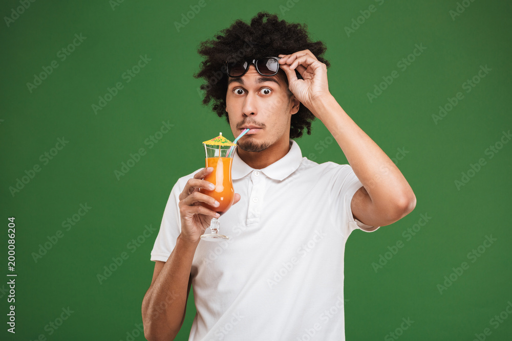 Shocked young african curly man drinking cocktail. Shocked young african curly man drinking cocktail.