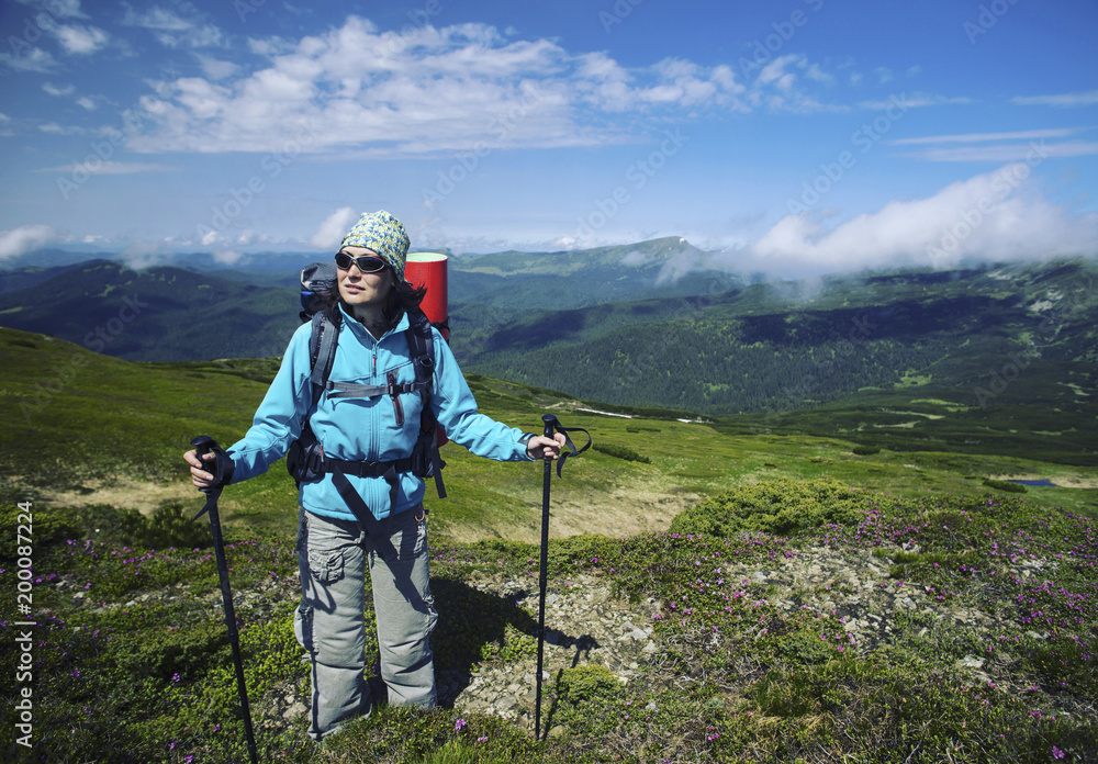 Summer hike in the mountains with a backpack and tent.