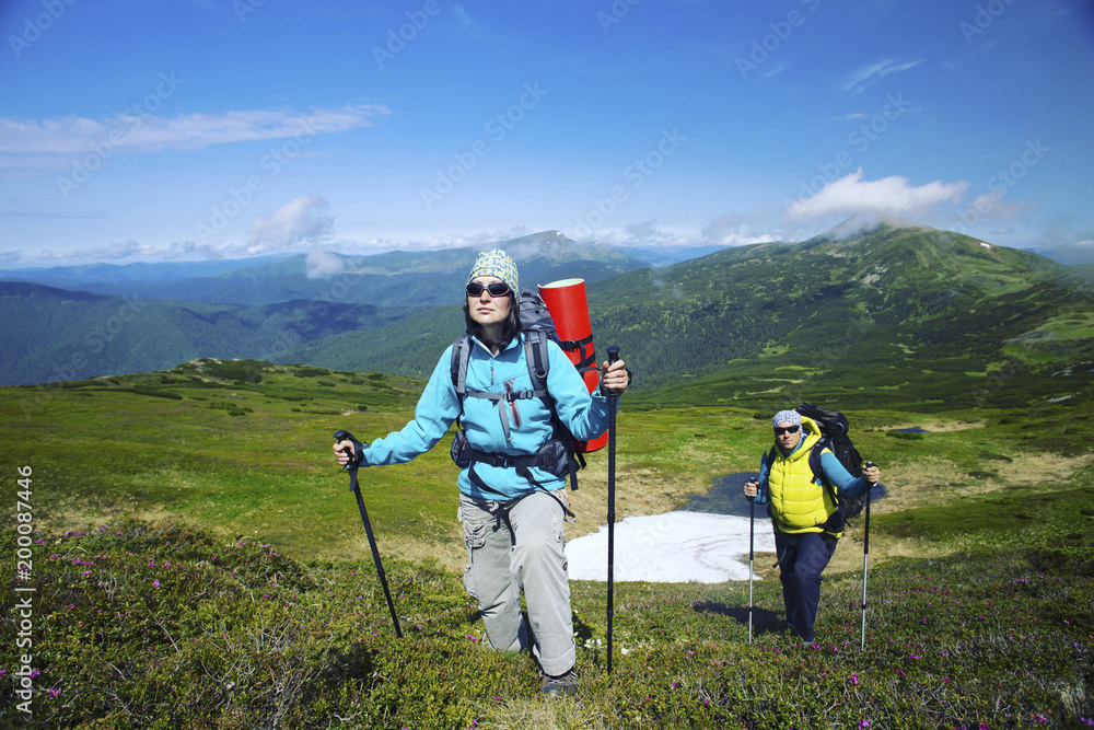 Summer hike in the mountains with a backpack and tent.