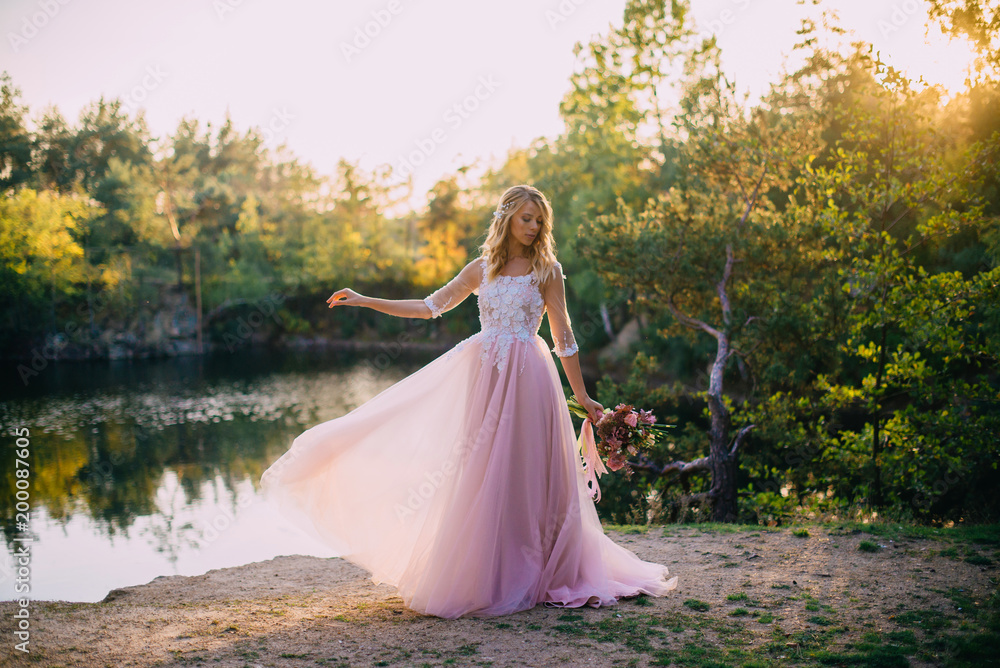 portrait of a young beautiful bride in the sun on a nature background