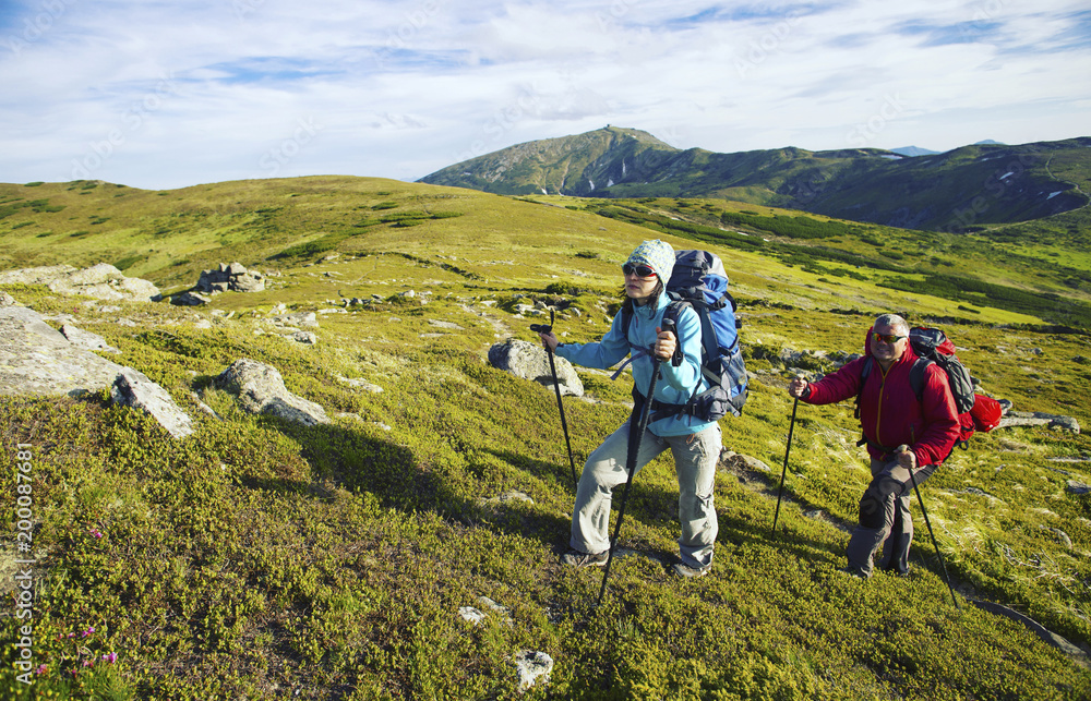 Obraz premium Summer hike in the mountains with a backpack and tent.