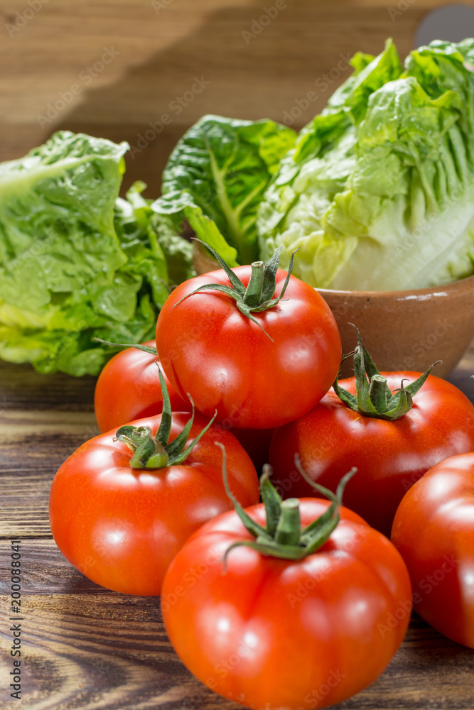 Tasty red ripe tomatoes gourmato from Belgium with green lettuce, ingredients for healthy salad close up Tasty red ripe tomatoes gourmato from Belgium with green lettuce, ingredients for healthy salad close up