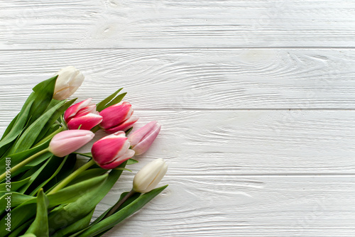 Fototapeta Naklejka Na Ścianę i Meble -  Beautiful bouquet of multicolored tulips on a white wooden background on white wooden background. Copy space
