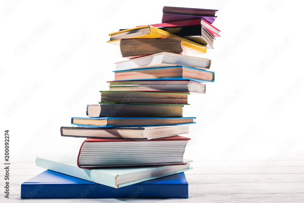 Books stacked in mess on white table Books stacked in mess on white table