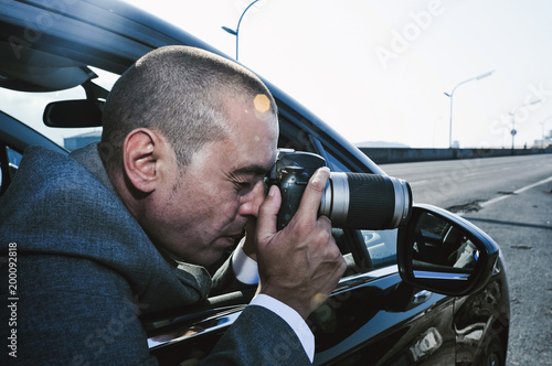 detective or paparazzi taking photos from a car.