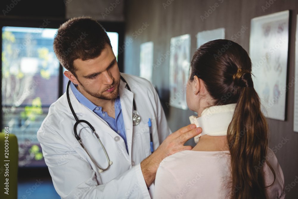Physiotherapist examining a female patient's neck Physiotherapist examining a female patient's neck