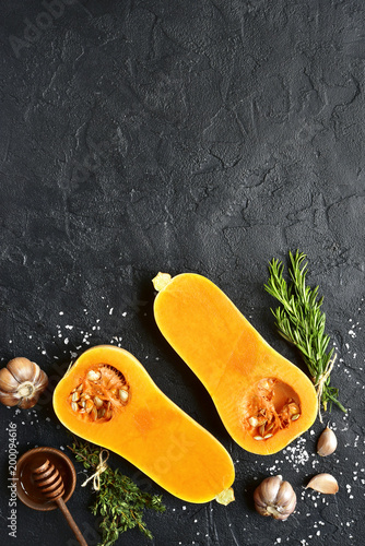 фотографія Halves of raw organic butternut squash with spices and ingredients for making