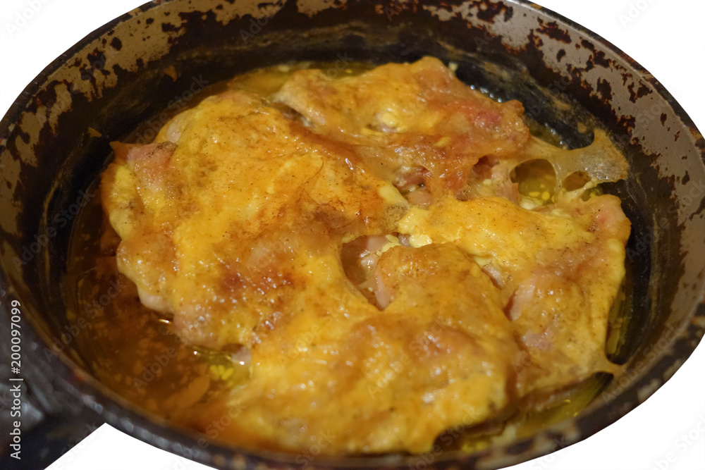 Запечённое мясо курицы под майонезом в чугунной сковороде, изолированной на белом фоне Запечённое мясо курицы под майонезом в чугунной сковороде, изолированной на белом фоне