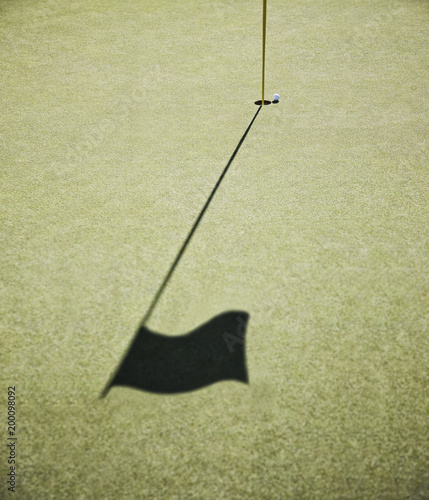 Shadow of a golf flag on the green of a golf course. photo