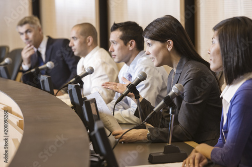 A political meeting with a mixed race group of people at microphones. photo