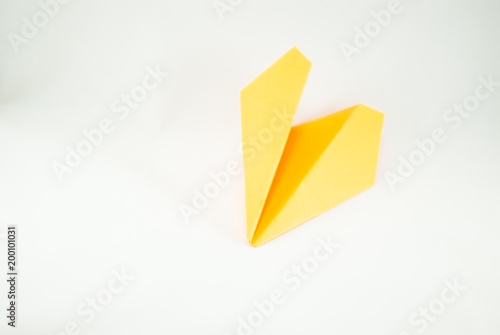 Free Download Yellow paper plane on a white background, isolated. Concept (idea) of airlines, freedom, leadership, success,  and creativity. Close-up - GFXLoad
