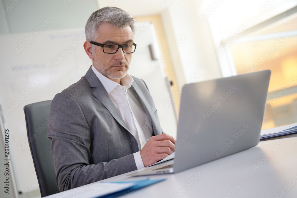 Businessman in office working on laptop Businessman in office working on laptop