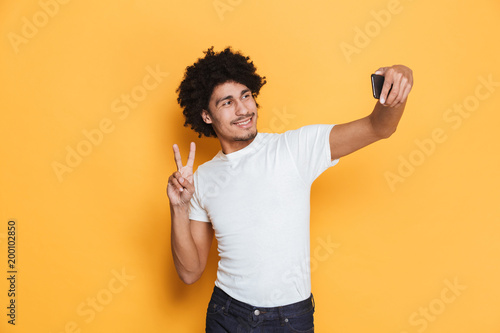 Portrait of a smiling young african guy taking a selfie