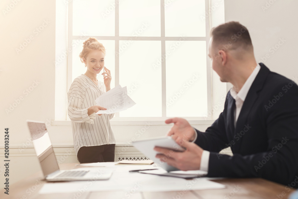 Male and female managers working on financial papers at modern office interior Male and female managers working on financial papers at modern office interior
