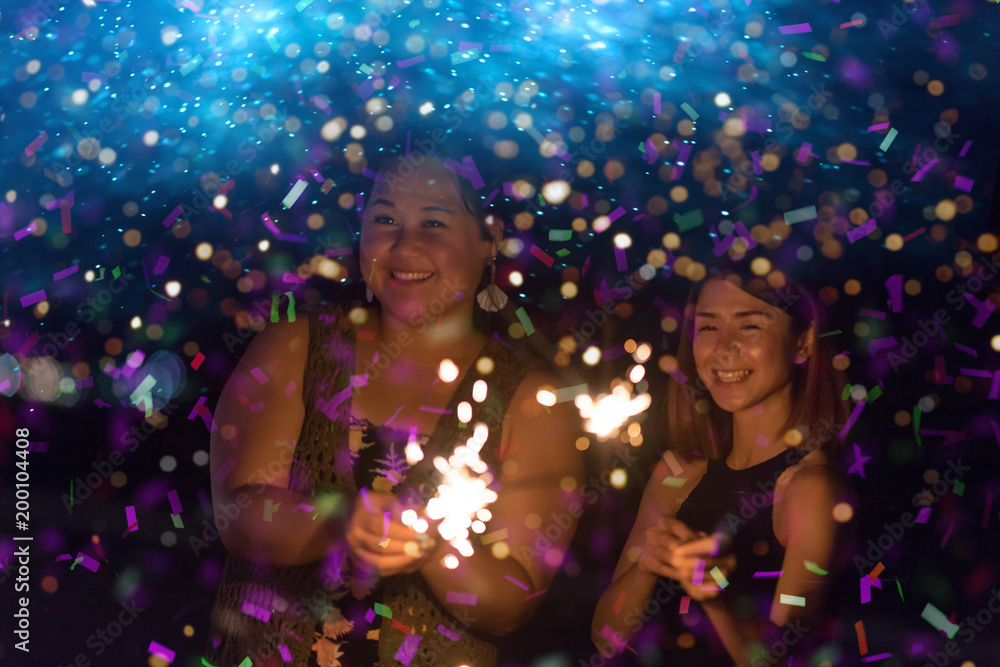 Abstract blurred of Sparklers with group of friends having fun for celebration and hand holding a burn sparkler light and playing together. Cinema film tone with grain.Dark concept. Abstract blurred of Sparklers with group of friends having fun for celebration and hand holding a burn sparkler light and playing together. Cinema film tone with grain.Dark concept.