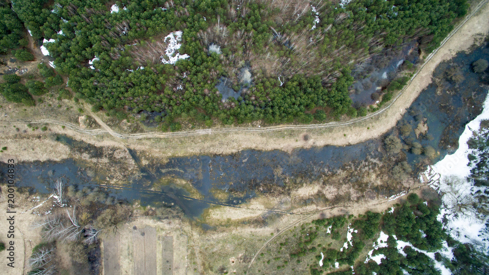 The landscape of green forest and water spill from the river. The spring nature in Europe from a bird's eye view