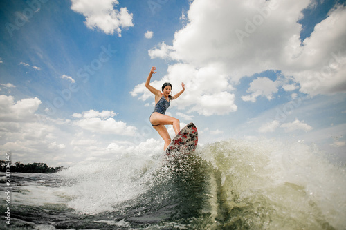 Sexy slim woman having fun wakesurfing anf jumping on the board