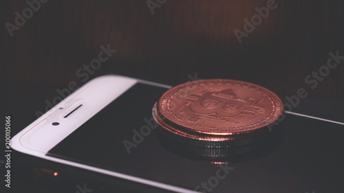 Gold, silver and bronze coin bitcoin, phone, Crypto currency course, dark background.