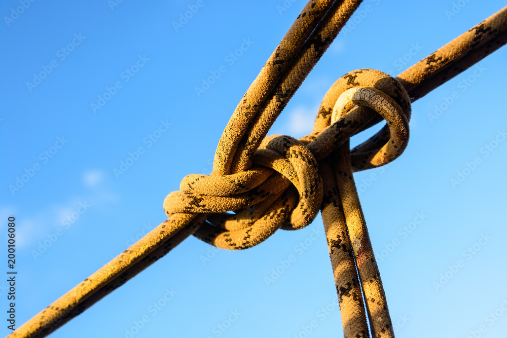 Closeup stretched and tied industrial braided rope Closeup stretched and tied industrial braided rope