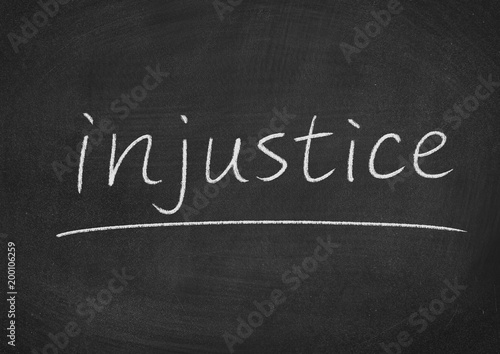 injustice concept word on a blackboard background