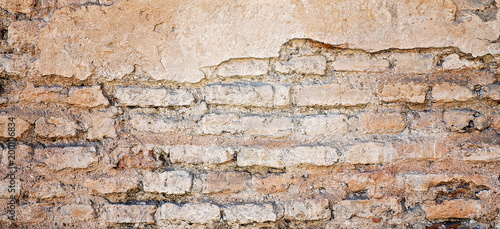 Old damaged rustic brick wall with plaster texture background
