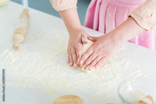 cropped image of woman kneading dough on kitchen counter