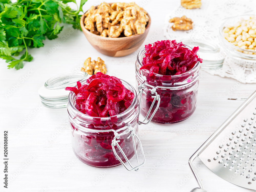 Fresh salad of grated boiled beetroot in glass jars, white wooden background, side view. Fresh salad of grated boiled beetroot in glass jars, white wooden background, side view.
