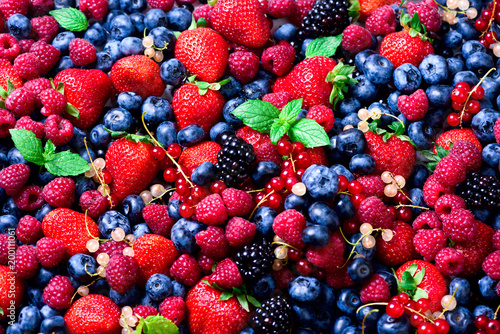 Fototapeta Naklejka Na Ścianę i Meble -  Macro colorful berries background. Top view. Summer food frame, border design. Assorted mix of strawberry, blueberry, raspberry, blackberry, currant, mint. Vitamin, vegan, vegetarian concept.