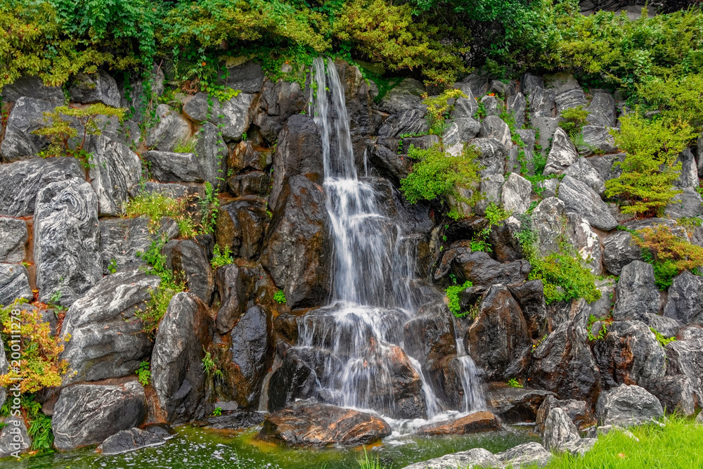 Fototapeta premium Small waterfall in public city park.