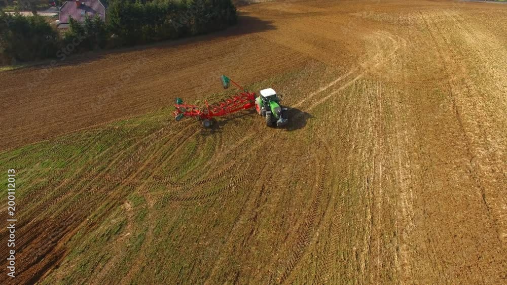 Tractor plowing a agricultural field - Tractor cultivating arable land for seeding crops, aerial view - 4K UHD - germany