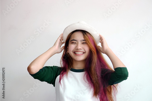 pretty asian femele smiling joyfully with colorful hair in dressed casually like hipster lifestyle,