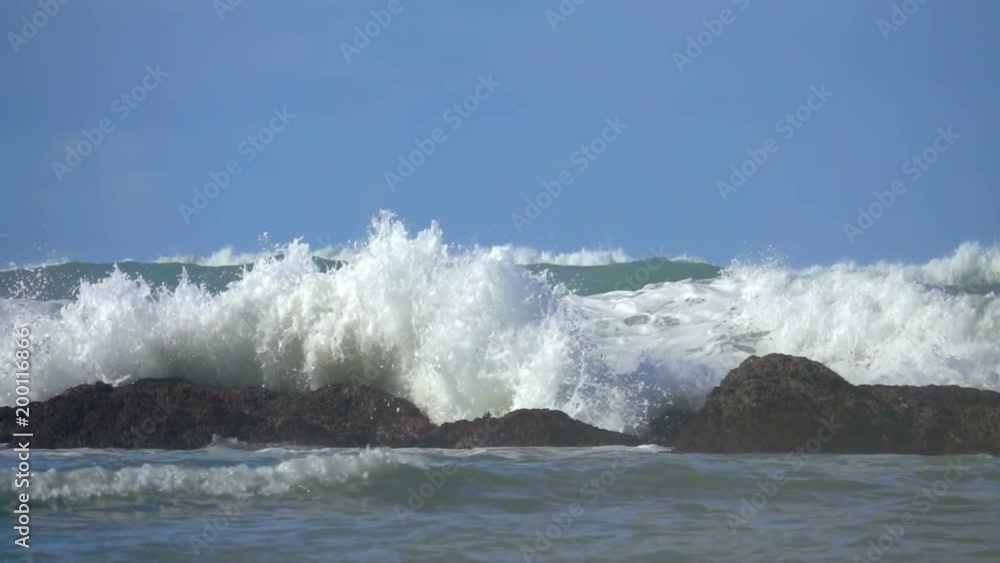Ocean sea wave crashes on the rock foam spray blue sky Ocean sea wave crashes on the rock foam spray blue sky
