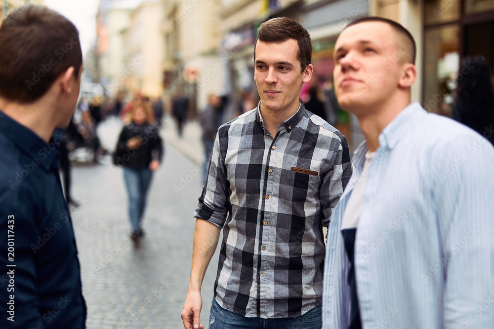 Three man talk on the street about business Three man talk on the street about business