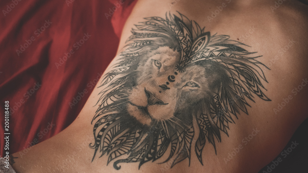 Sexy woman with lion tattoo at her back lying on the bed foto de Stock |  Adobe Stock