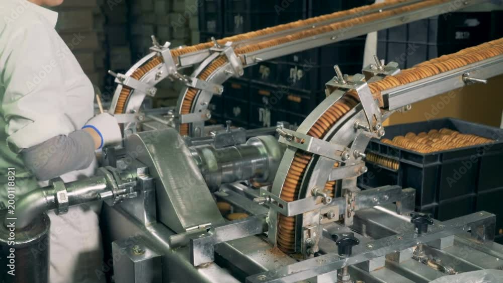 Control of production line for cookies by female worker. Control of production line for cookies by female worker.