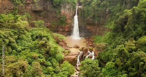 Beautiful aerial landscape of Cimarinjung waterfall and tropical jungle from a drone flying from right to left at Ciletuh Geopark, Sukabumi, West Java, Indonesia. Shot in 4k resolution photo