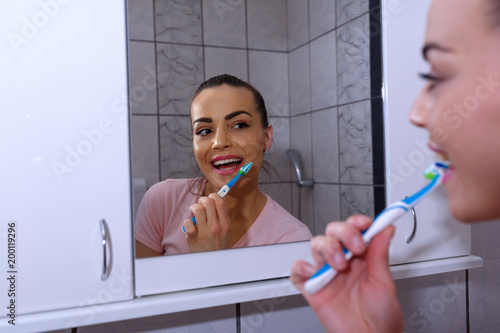 beauty and dental health concept - beautiful woman brushing her teeth.