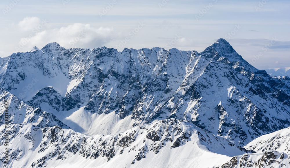 Mountain panorama. A view of a magnificent ridge in the snow on a sunny day.