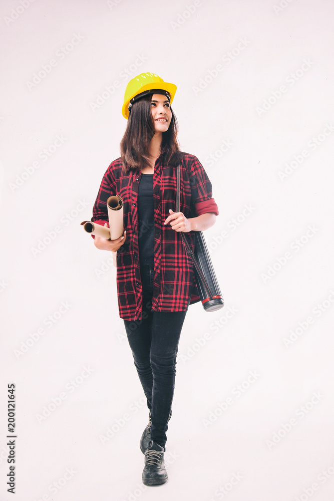 The young woman engineer with yellow safety helmet and black safety shoe,hold blue print in hand,with smile and happy face, The young woman engineer with yellow safety helmet and black safety shoe,hold blue print in hand,with smile and happy face,