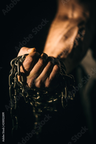Fist hand holds the chain. Concept fitness, lifting, fitness. © Volodymyr