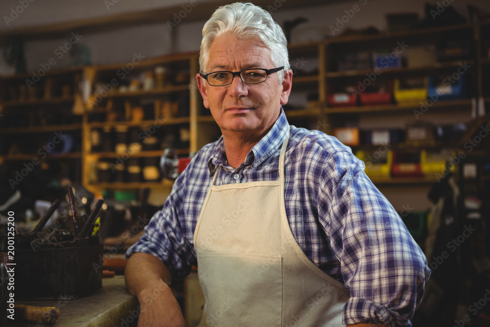 Portrait of shoemaker sitting in workshop Portrait of shoemaker sitting in workshop