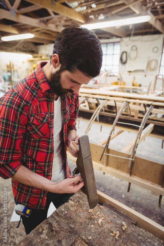 Man adjusting a hand plane Man adjusting a hand plane