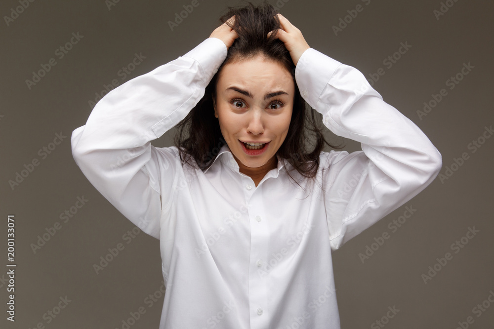 Beautiful girl in a white shirt shows emotions - surprise, shock, On a light background. Beautiful girl in a white shirt shows emotions - surprise, shock, On a light background.